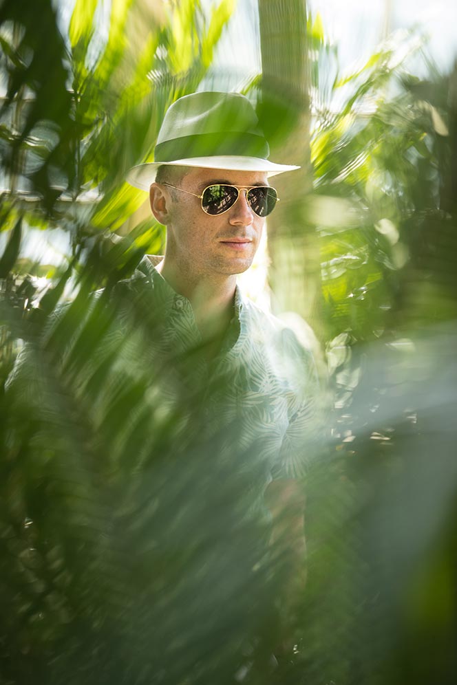 looking-through-palm-trees-casual-mens-summer-outfit-ideas-printed-shirt-panama-hat-aviator-sunglasses