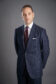 Custom-tailored navy suit with narrow chalk stripe detailing.