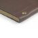 Brown smooth leather notebook cover with brass stud closure, a close-up of the corner and pages