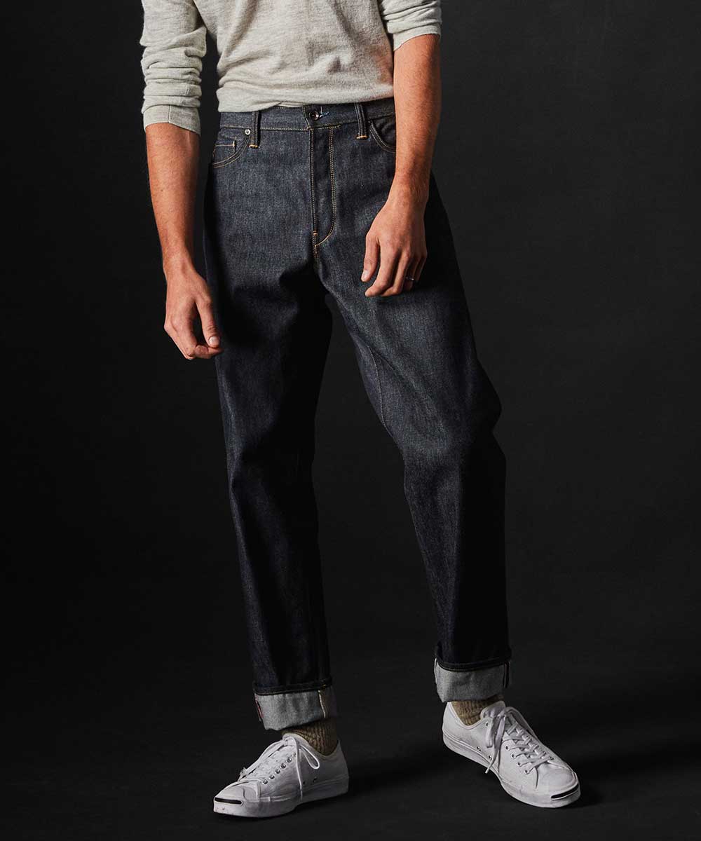 Raw denim jeans cuffed with sneakers and sweatshirt