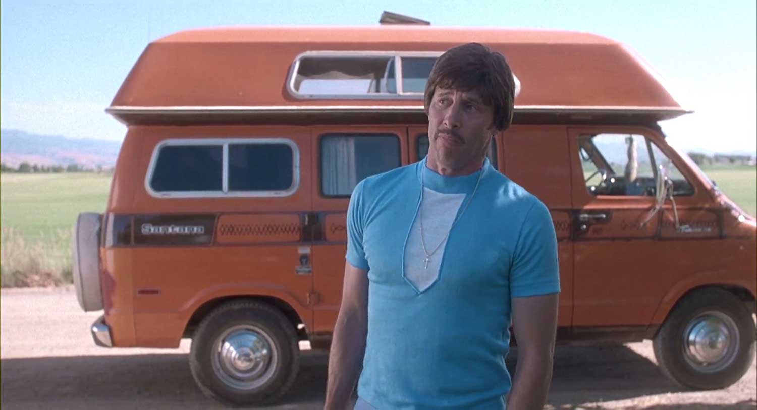 Uncle Rico from Napoleon Dynamite standing in front of orange van