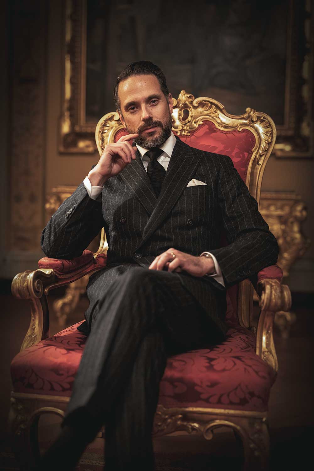 brian sacawa sitting in an ornate chair wearing a db gray chalkstripe flannel suit