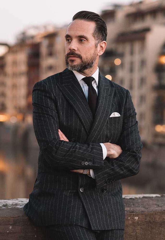 wearing a gray chalkstripe flannel suit for a formal occasion