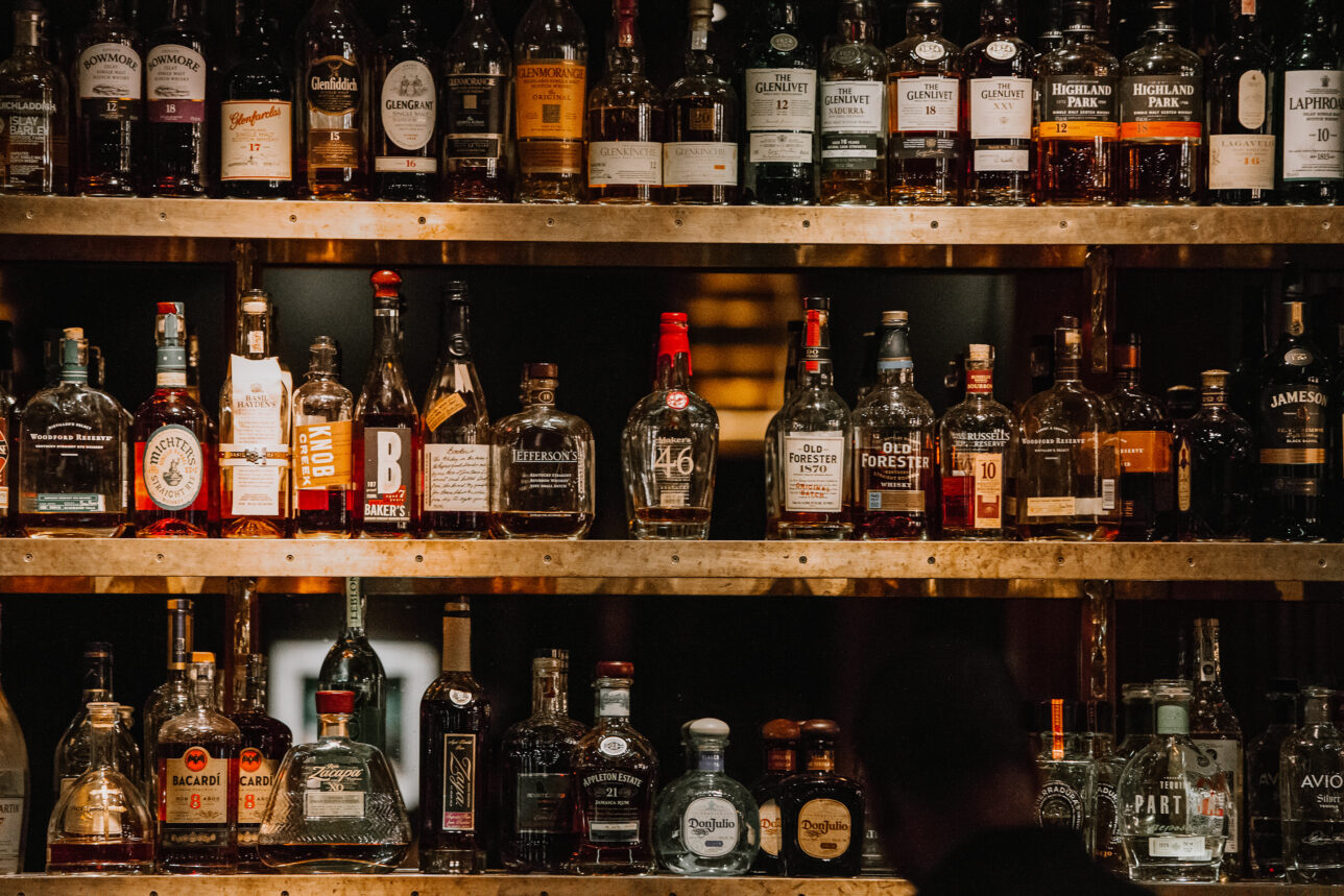 bottles-of-bourbon-above-bar | He Spoke Style