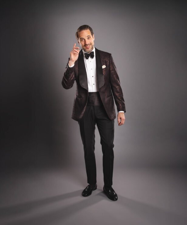 Brown jacquard shawl collar dinner jacket with pique stud shirt, black bow tie and cummerbund