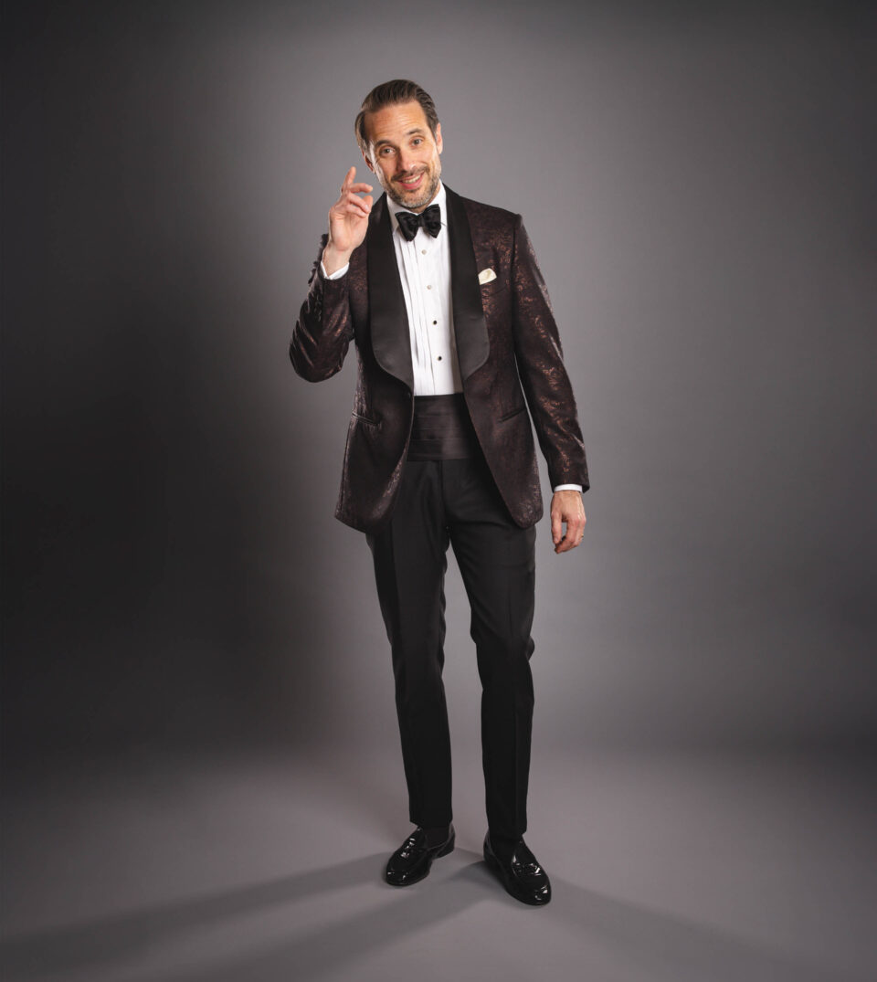 Brown jacquard shawl collar dinner jacket with pique stud shirt, black bow tie and cummerbund