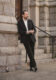 Black flannel sport coat with white shirt, olive corduroy trousers and black loafers, worn by a model outdoors