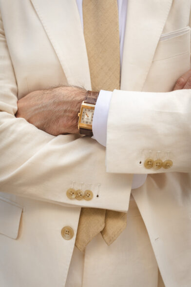 A Jaeger-LeCoultre Reverso in gold paired with a cream linen suit
